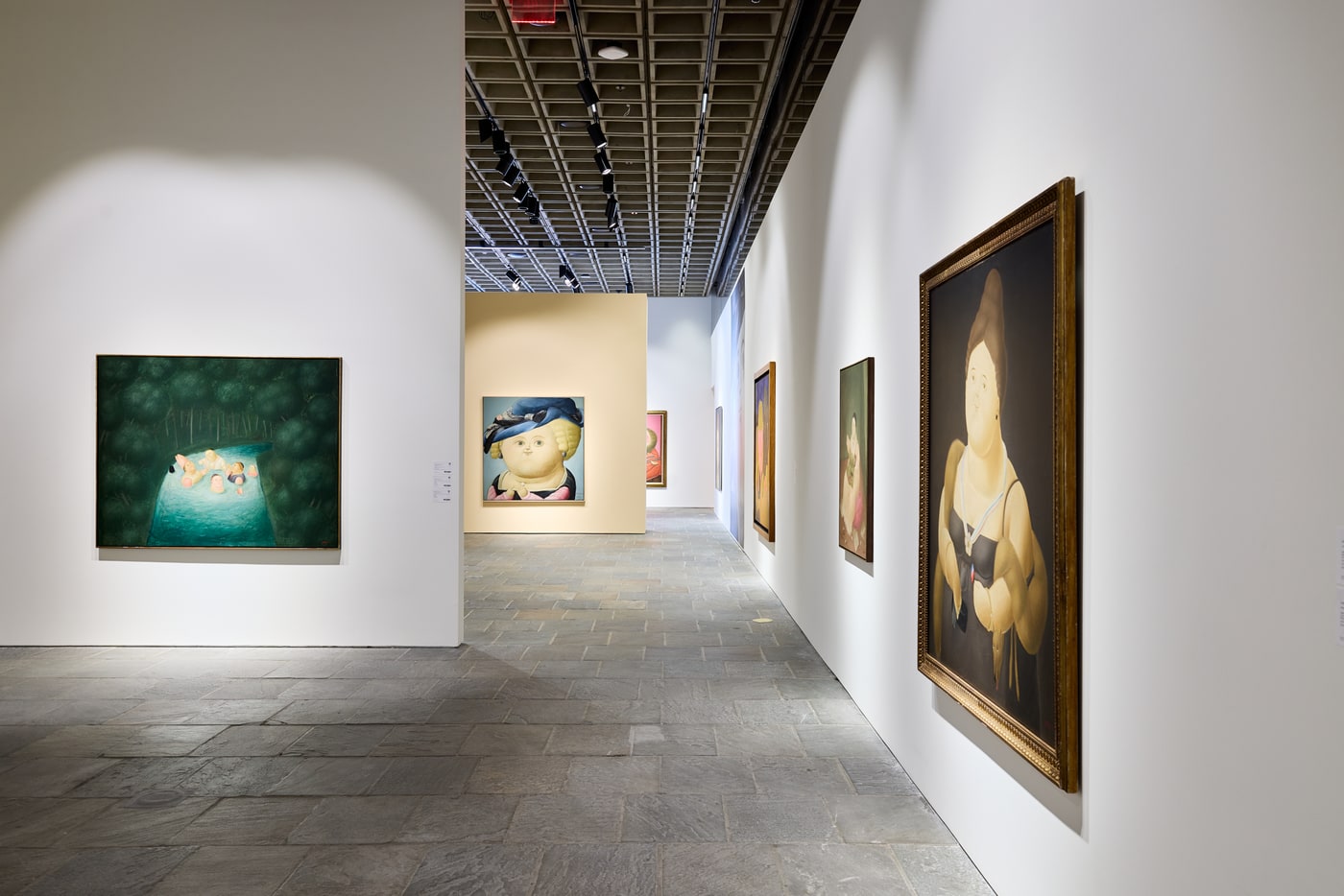 A corridor with bathers in a green pool at left, a large gold-framed portrait of a woman in a black bodice in the right foreground, and further works receding.